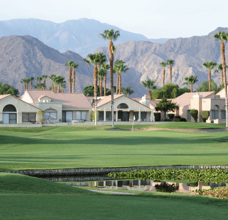 Golf course homes, mountains backdrop.